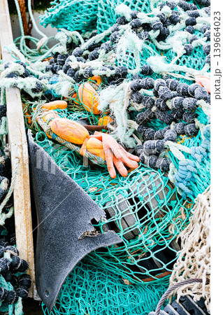 Fishing nets and ropes on wooden dock near water Fishing nets and ropes on wooden dock near water 139664023