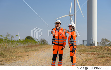 Wind energy engineers conducting site inspection at wind farm facility 139665029