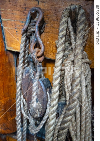 Old sailing ship ropes and wooden pulleys on a historic vessel Old sailing ship ropes and wooden pulleys on a historic vessel 139665589