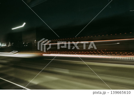 Light trails of a moving vehicle at night on the road Light trails of a moving vehicle at night on the road 139665610