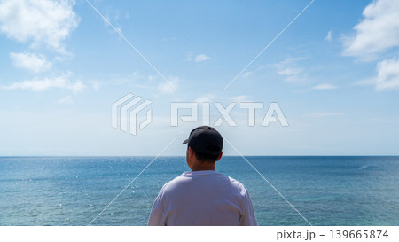 夏の海を眺める男性の後ろ姿(沖縄県中頭郡北谷町・宮城海岸/リフレッシュ・人物中央・横向き) 夏の海を眺める男性の後ろ姿(沖縄県中頭郡北谷町・宮城海岸/リフレッシュ・人物中央・横向き) 139665874