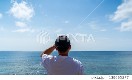 夏の眩しい太陽の海を眺める男性の後ろ姿(沖縄県中頭郡北谷町・宮城海岸/リフレッシュ・人物中央) 夏の眩しい太陽の海を眺める男性の後ろ姿(沖縄県中頭郡北谷町・宮城海岸/リフレッシュ・人物中央) 139665877