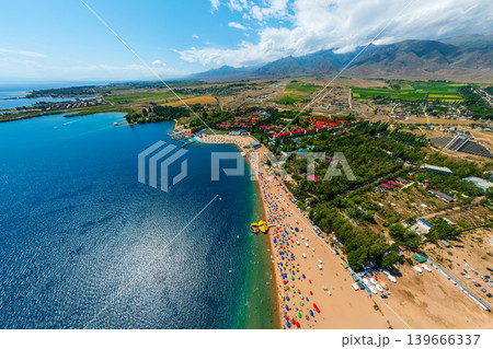 Aerial view of crowded beach with colorful umbrellas and lake 139666337