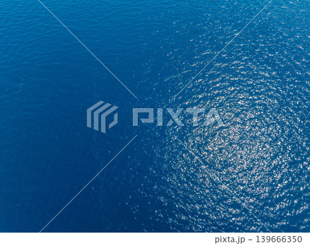 Aerial view of deep blue ocean water with sunlight reflections Aerial view of deep blue ocean water with sunlight reflections 139666350
