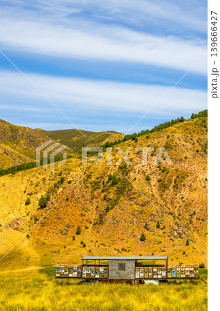 Mobile Beehive Apiary in a Golden Meadow with Rolling Hills in Kyrgyzstan Mobile Beehive Apiary in a Golden Meadow with Rolling Hills in Kyrgyzstan 139666427