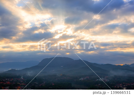 Beautiful sunrise over mountainous landscape in Luang Prabang, Laos. Soft light, clouds and mist create peaceful and atmospheric scenery. Beautiful sunrise over mountainous landscape in Luang Prabang, Laos. Soft light, clouds and mist create peaceful and atmospheric scenery. 139666531