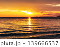 Bright and colorful sunset over the ocean with intense orange tones and shimmering water surface. Ideal tropical travel background with romantic and warm evening atmosphere. 139666537