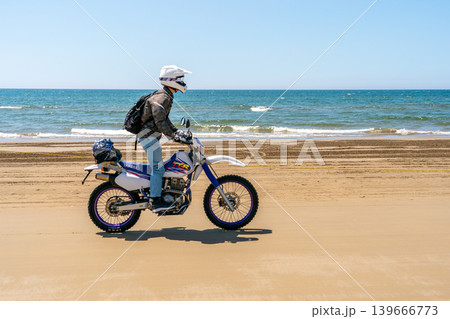 千里浜なぎさドライブウェイをオフロードバイクでツーリングする男性※作品コメント欄に撮影位置 139666773