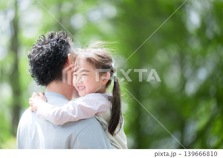 新緑の公園で父親に抱きつく笑顔の女の子 親子愛と幸せな家族時間　パパ大好き～父の日などのイメージにも 139666810