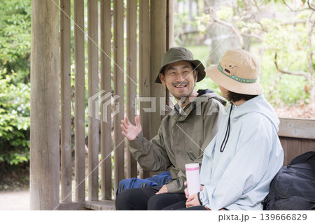登山の東屋や公園で休憩し会話を楽しむ40代夫婦 レジャーやお出かけのイメージ 登山の東屋や公園で休憩し会話を楽しむ40代夫婦 レジャーやお出かけのイメージ 139666829
