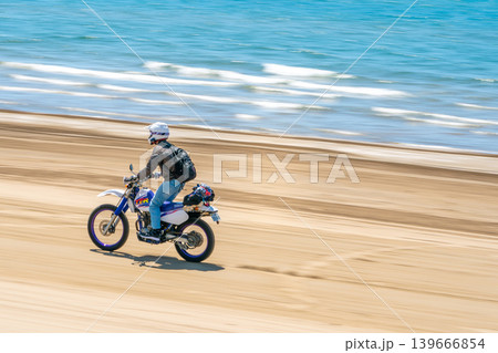 千里浜なぎさドライブウェイを走るオフロードバイクの流し撮り※作品コメント欄に撮影位置 139666854