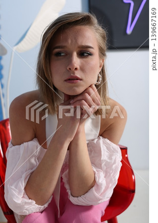 Professional woman in pink attire and white hat on neon background Professional woman in pink attire and white hat on neon background 139667169