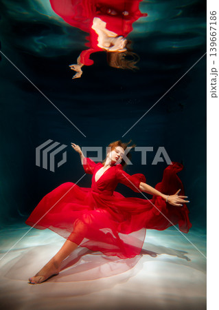 Woman in red silence. Quiet female figure draped in scarlet clothing 139667186