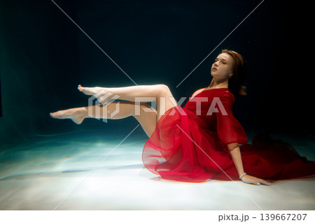Underwater scene featuring poised dancer in flowing attire Underwater scene featuring poised dancer in flowing attire 139667207