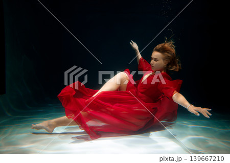 Serene scene of woman drifting over rippling surface in elegant costume Serene scene of woman drifting over rippling surface in elegant costume 139667210