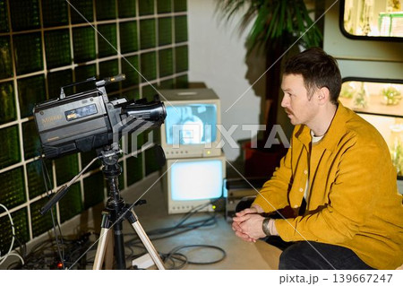 Independent filmmaker analyzing retro camera and monitor in studio 139667247