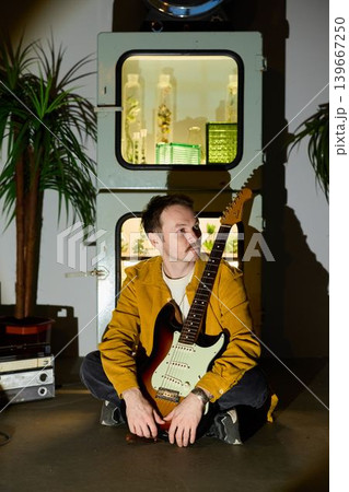 Creative portrait of artist with electric guitar and stylish background 139667250