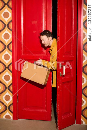 Man with ribboned box at doorway signifies heartfelt reunion and warmth Man with ribboned box at doorway signifies heartfelt reunion and warmth 139667257