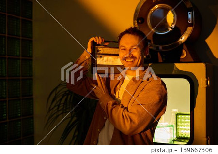 Artistic individual displaying vintage audio devices confidently 139667306