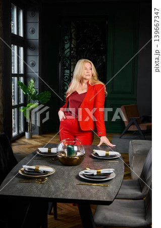 Poised female professional in red blazer at upscale restaurant table Poised female professional in red blazer at upscale restaurant table 139667347