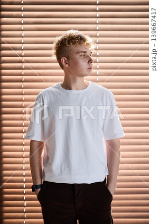Caucasian teenager directs gaze towards sunlight streaming inside room 139667417