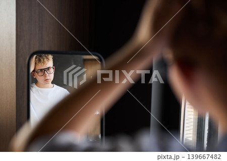 Performer adjusts glasses while practicing lines in quiet room Performer adjusts glasses while practicing lines in quiet room 139667482