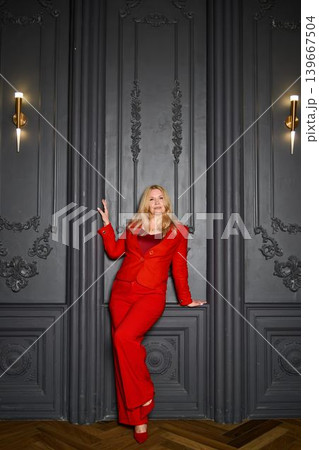 Stylish woman exuding confidence near intricate wall decor during night 139667504