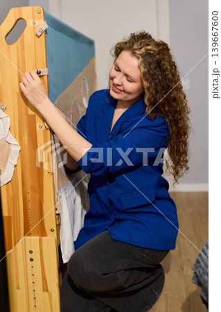 Woman smiles proudly after organizing playpen components successfully Woman smiles proudly after organizing playpen components successfully 139667600