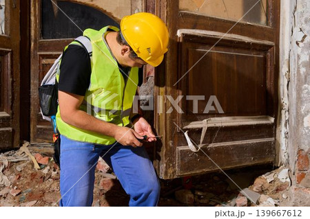 Construction worker inspecting door structure carefully Construction worker inspecting door structure carefully 139667612