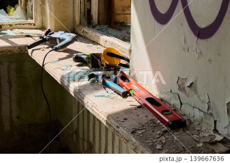 Dilapidated space filled with rusted tools and peeling plaster walls Dilapidated space filled with rusted tools and peeling plaster walls 139667636