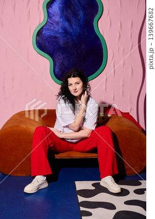 Stylish woman strikes confident pose with artistic background 139667682