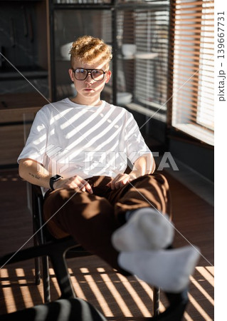 Original music creator relaxing with beverage and socks in sunlight Original music creator relaxing with beverage and socks in sunlight 139667731
