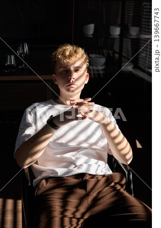 An imaginative individual seated peacefully amidst subtle kitchen details An imaginative individual seated peacefully amidst subtle kitchen details 139667743