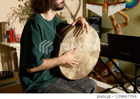 Caucasian percussion instructor demonstrating frame drum technique Caucasian percussion instructor demonstrating frame drum technique 139667769