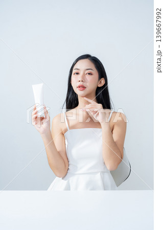 Asian woman holding product isolated on white background for promotion advertising. Asian woman holding product isolated on white background for promotion advertising. 139667992