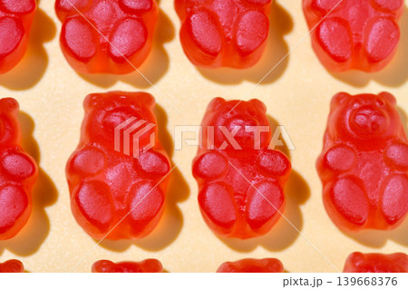 Jelly gummy bears flat lay, fruit vitamins on bright background, food supplements.Orange vitamins on yellow background, macro photography Jelly gummy bears flat lay, fruit vitamins on bright background, food supplements.Orange vitamins on yellow background, macro photography 139668376