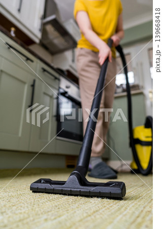 Vacuuming the floor. Close up of vacuum cleaner, kitchen. Household and useful technology lifestyle. Copy space Vacuuming the floor. Close up of vacuum cleaner, kitchen. Household and useful technology lifestyle. Copy space 139668418