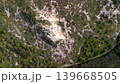 Top-down aerial view of coastal sand dunes covered in green scrub vegetation. Natural texture pattern of a dune landscape with animal tracks and small footprints in the sand. 139668505