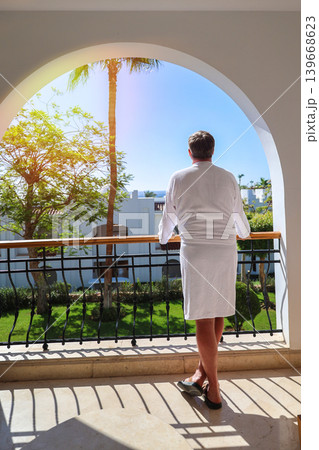 Man standing on balcony admiring the beauty of nature, enjoying the tranquility of the outdoors, view from back Man standing on balcony admiring the beauty of nature, enjoying the tranquility of the outdoors, view from back 139668623