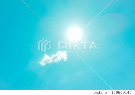 晴れ渡る青空に輝く太陽とふわふわな白い雲 139669140