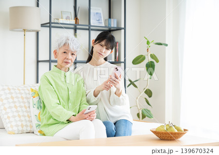 スマホで悩むシニアの母親とミドルの娘 スマホで悩むシニアの母親とミドルの娘 139670324