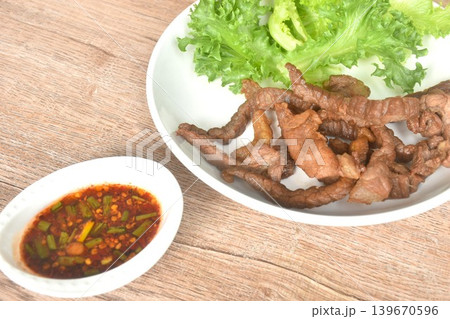 fried crispy salty fermenting beef fat meat with pepper on plate dipping Thai spicy chili tamarind sauce 139670596