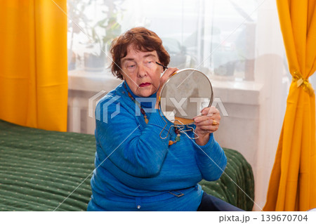 Senior Caucasian woman brushing eyebrows and using powder indoors. Detailed grooming and confidence. Concept of beauty lifestyle. 139670704