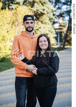 Caucasian husband and wife standing together on park walkway and looking at camera outdoors. Marriage and relationship lifestyle 139670768