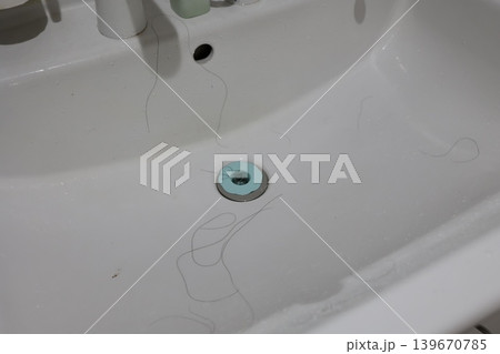 洗面台の排水口に付着した長い髪の毛。ヘアトラップ。脱毛対策 洗面台の排水口に付着した長い髪の毛。ヘアトラップ。脱毛対策 139670785