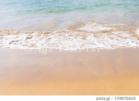 Gentle ocean waves lapping on a sandy beach under clear blue sky Gentle ocean waves lapping on a sandy beach under clear blue sky 139670828