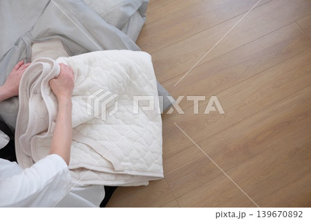 収納袋に冬用布団をしまう女性 収納袋に冬用布団をしまう女性 139670892