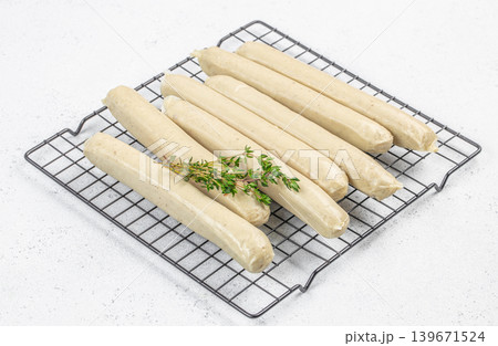 White sausages on cooling rack with thyme 139671524