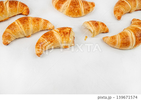 Fresh croissants with bitten pastry on white background, breakfast food banner with copy space Fresh croissants with bitten pastry on white background, breakfast food banner with copy space 139671574