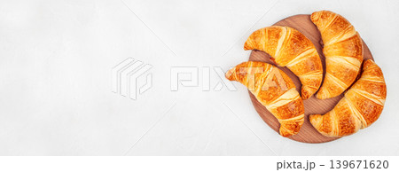 Fresh baked croissants on wooden board over white background with copy space, top view Fresh baked croissants on wooden board over white background with copy space, top view 139671620